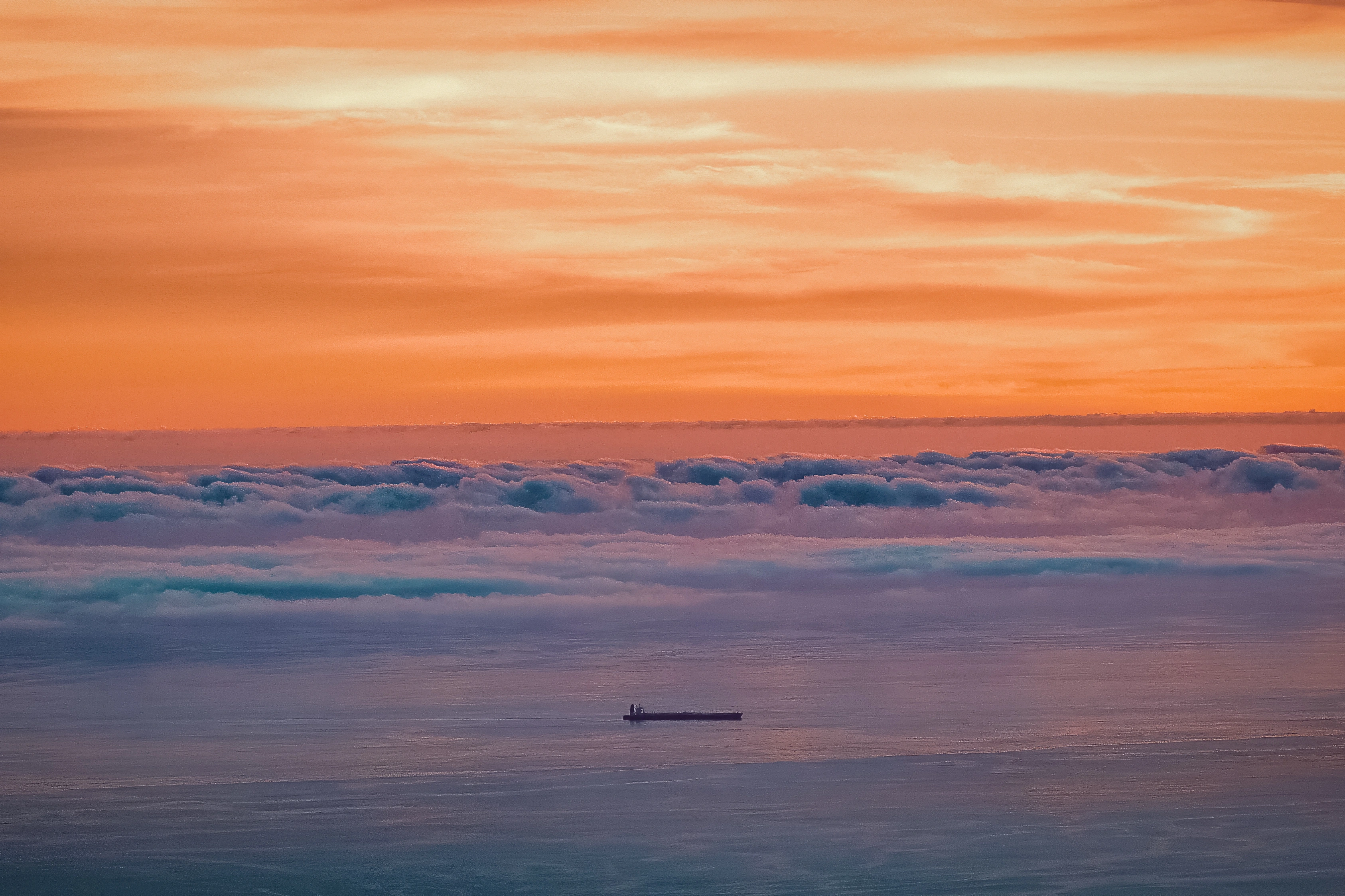 A small ship sits below a horizontal cloud bank over pink and purple water.